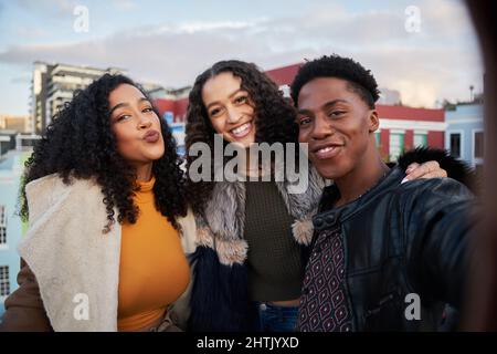 Eine Gruppe verschiedener Freunde, die auf der Dachparty Selfie machen. Posiert für die Kamera, glücklich und lachend im Stadtleben Stockfoto