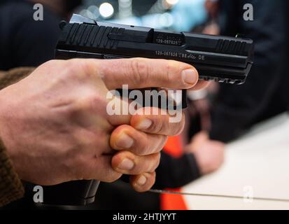 Nürnberg, Deutschland. 01. März 2022. Ein Mann hält die P30-V3 Pistole am Heckler & Koch-Stand auf der Enforce Tac. Es hat ein Kaliber von 9mm x 19. Die Fachmesse für Sicherheitstechnik „Enforce Tac“ mit mehr als 300 Ausstellern findet am 1. Und 2. März statt. Quelle: Nicolas Armer/dpa/Alamy Live News Stockfoto