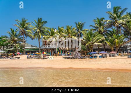 HIKKADUWA, SRI LANKA - 22. JANUAR 2022: Nicht identifizierte Menschen am Strand von Hikkaduwa. Narigama Surfer Beach Stockfoto