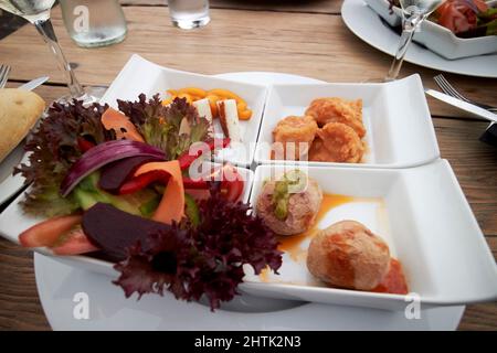 Typisch kanarisches Essen Tapas von kanarischen Kartoffeln, gebratene Fischstücke Ziegen Käse und Salat serviert auf Lanzarote, kanarische Inseln, spanien Stockfoto