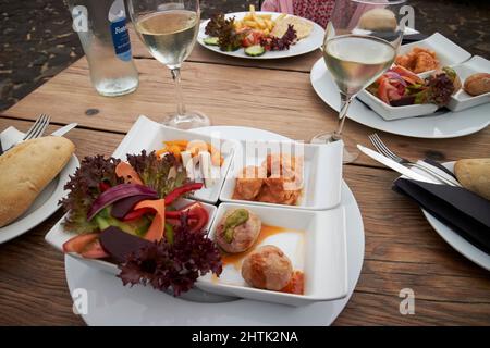 Typisch kanarisches Essen Tapas von kanarischen Kartoffeln, gebratene Fischstücke Ziegen Käse und Salat serviert auf Lanzarote, kanarische Inseln, spanien Stockfoto