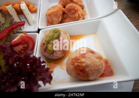 Typisch kanarisches Essen Tapas von kanarischen Kartoffeln, gebratene Fischstücke Ziegen Käse und Salat serviert auf Lanzarote, kanarische Inseln, spanien Stockfoto