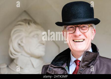 London, Großbritannien, 01.. März 2022. Ein „Beadle“, ein zeremonielles Büro mit der Worshipful Company of Tax Advisers, posiert in einem Melonenhut mit einer Büste von Cromwell und lächelt trotz des heftigen Regens in der Guildhall. Vertreter der Livreen der City of London und der worshipful Companies in ihren Regalien und ihren ausgefallenen Kleidern sind alle gekommen, um sich beim Inter Livery Pancake Race am Faschingsdienstag, auch gemeinhin als „Pancake Day“ bezeichnet, gegeneinander anzutreten. Das Rennen, das jetzt 18. Jahre alt ist, findet immer im Guildhall Yard statt, wird aber in diesem Jahr auf einen zeremoniellen „Wurf“ reduziert, da das Gelände im Regen zu rutschig ist. Stockfoto