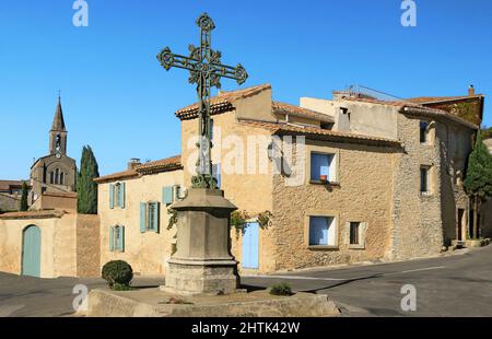 Monumentales Kreuz auf dem Platz eines Dorfes in Provençal. Stockfoto