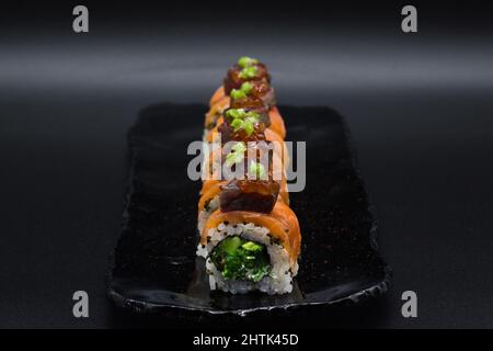 Farbenfrohe Kombination aus traditioneller japanischer Uramaki Sushi-Rolle mit. Frontalansicht. Stockfoto