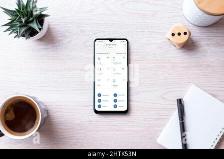 Home Automation Control App Konzept auf Smartphone. Überwachungs- und Steuerungssystem-App mit moderner Schnittstelle. Draufsicht, flache Tischaufteilung Stockfoto