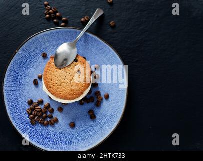 Eis-Sandwich mit Schokoladenkeksen auf blauem Teller. Draufsicht. Kopierraum Stockfoto
