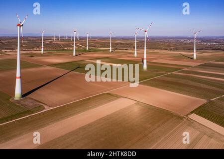 Luftaufnahme von riesigen Windmühlen zwischen Feldern in der Sonne im Winter Stockfoto