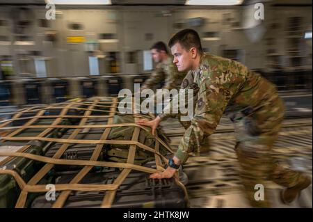 Amari Air Base, Estland. 01. März 2022. Ladermeister der US Air Force, Senior Airman Michael McDougall, entlädt Fracht von C-17 Globemaster III-Flugzeugen auf der Amari Air Base am 1. März 2022 in Amari, Estland. Die Ladung soll die NATO-Verbündeten und die verstärkten Luftpolizistenoperationen unterstützen, um der russischen Behandlung gegenüber der Ukraine entgegenzuwirken. Kredit: SSGT. Megan Beatty/U.S. Air Force/Alamy Live News Stockfoto