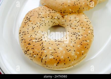 Dünne Bagels, isoliert auf einem weißen Teller Stockfoto