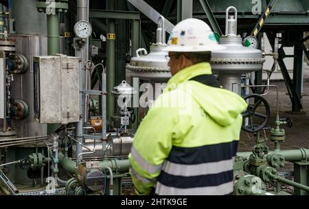 Kiel, Deutschland. 01. März 2022. Ein Mitarbeiter der Stadtwerke Kiel steht vor den Rohren des Gasspeichers der Stadtwerke. Energiewende Staatssekretär Goldschmidt informierte sich über den Gasspeicher der Stadtwerke Kiel. Quelle: Axel Heimken/dpa/Alamy Live News Stockfoto