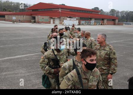 Savannah, Usa. 27.. Februar 2022. Soldaten der US-Armee, die dem Kampfteam der Panzerbrigade 1., der Infanterie-Division 3., zugewiesen wurden, werden von befehlshabenden Offizieren mit der Faust gestoßen, während sie vom Hunter Army Airfield, 27. Februar 2022 in Savannah, Georgia, ein ziviles Flugzeug für den Einsatz in NATO-Ländern besteigen. Die Soldaten enteignen sich nach Osteuropa, um NATO-Verbündete zu unterstützen und die russische Aggression gegenüber der Ukraine abzuschrecken. Kredit: Capt. John D. Howard Jr/U. S Army/Alamy Live Nachrichten Stockfoto