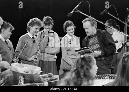 Sir Richard Stilgoe, OBE, unterhielt sich 1987 mit jungen Musikern bei einem der Schools Prom Konzerte in der Royal Albert Hall, London. Stockfoto