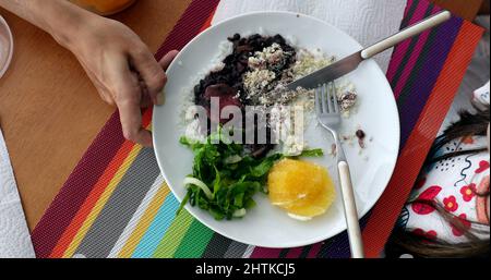 Kinder essen Feijoada traditionelle brasilianische Platte Reis Bohnen und Gemüse Stockfoto