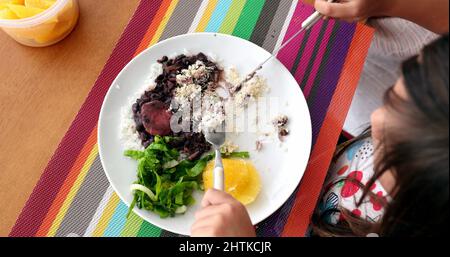 Kinder essen Feijoada traditionelle brasilianische Platte Reis Bohnen und Gemüse Stockfoto