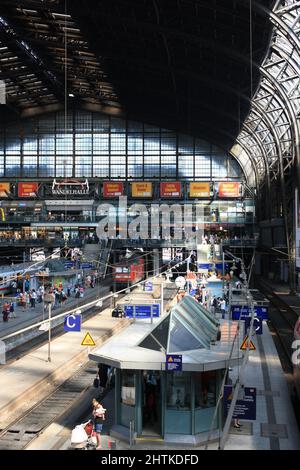 Innenraum der Wandelhalle, einer großen Halle des Hamburger Haupt- oder Hauptbahnhofs im Sommer. Menschenmenge, die auf dem Bahnsteig auf die Abfahrt wartet. Stockfoto