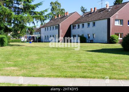 Blick auf billige Wohnung mit grünem Rasen im Garten im sonnigen Sommer mit Bäumen und klaren blauen Himmel Hintergrund. Keine Personen. Stockfoto