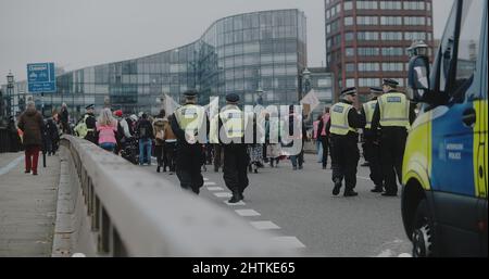 London, Großbritannien - 11 20 2021: Polizeibeamte und ein Polizeiwagen auf der Lambeth Bridge mit einer Menge von beleidigenden britischen Demonstranten. Stockfoto