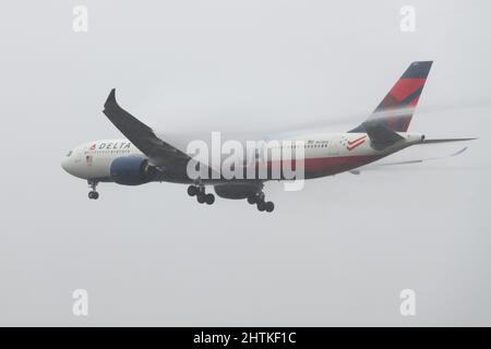 SeaTac, WA, USA - 28. Februar 2022; Delta Air Lines Airbus A330-900 im Team USA-Lackierung, die bei schlechtem Wetter mit einem Wirbelsturm hinter dem Flügel landete Stockfoto