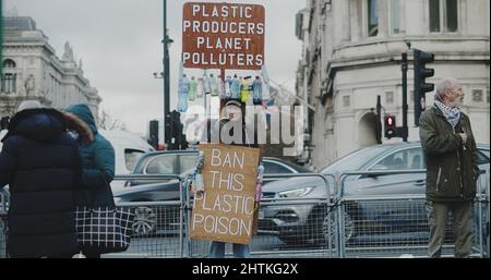 London, Großbritannien - 12 13 2021: Ein Protestant, der auf dem Parliament Square mit einem Schild ‘Plastic Producers Planet Polluters’ bei einer Freiheitskundgebung steht. Stockfoto