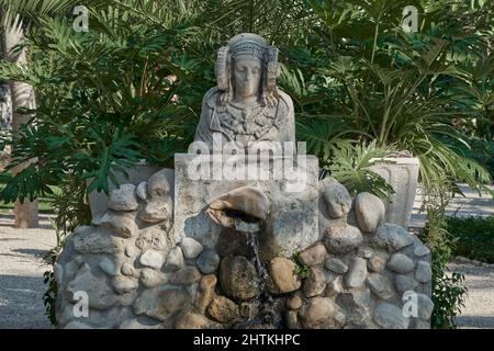 Brunnen und Tribut an die Büste der Dame von Elche im Palmenhain von Elx, Huerto del Cura, Spanien Stockfoto