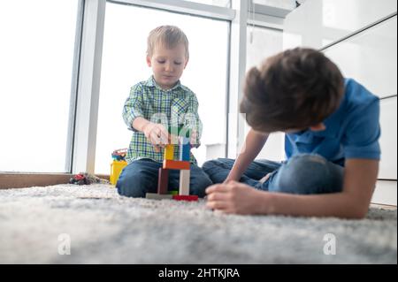 Zwei Jungen, die in einem Raum mit Spielzeugblöcken spielen Stockfoto