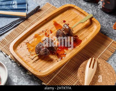 Kalorienarme Shiitake-Pilze klebt in Holzschale isoliert Mate und grauen Hintergrund Draufsicht Stockfoto