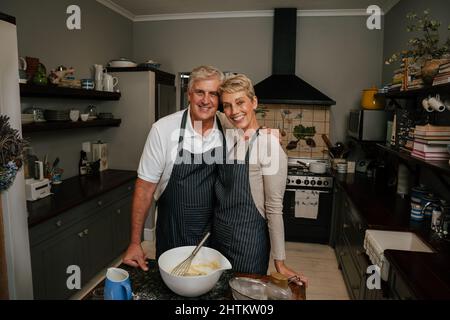 Lächelndes kaukasisches älteres Paar, das in der Küche steht Stockfoto