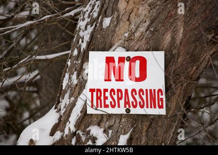 Kein Trespassing-Zeichen auf einem Baumstamm in einer ländlichen Umgebung gepostet Stockfoto