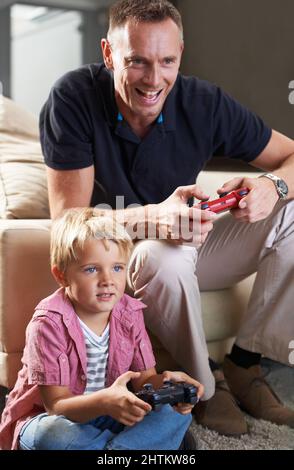 Hes ein begeisterter Gamer. Ein kleiner Junge, der zu Hause Videospiele spielt. Stockfoto