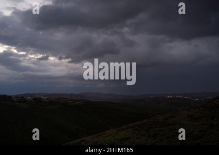 Schwere Sturmwolken im Morgengrauen, über den Wüstenbergen von Judäa, östlich von Jerusalem, Israel. Stockfoto