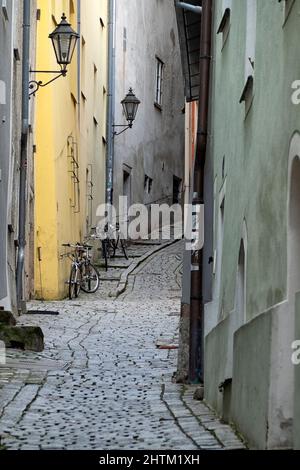 PASSAU, DEUTSCHLAND - 12. JULI 2019: In einer engen Gasse in der Altstadt geparkte Fahrräder Stockfoto