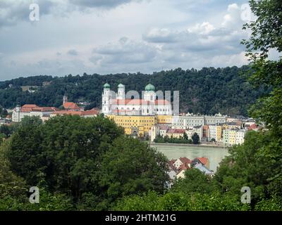 PASSAU, DEUTSCHLAND - 12. JULI 2019: Blick auf den Stephansdom über den Inn durch Bäume Stockfoto