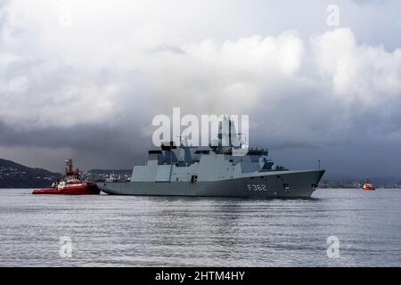 Dänische Fregatte der Ver Huitfeldt-Klasse F362 HDMS Peter Willemoes in Byfjorden, vor dem Hafen von Bergen, Norwegen. Schlepper BB Coaster in der Nähe. Eine dunkle, regnerische A Stockfoto