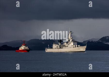 Niederländische Karel-Doorman-Klasse Fregatte F3831 HNLMS Van Amstel in Byfjorden, außerhalb des Hafens von Bergen, Norwegen. Schlepper BB Worker in der Nähe, um zu helfen. Stockfoto