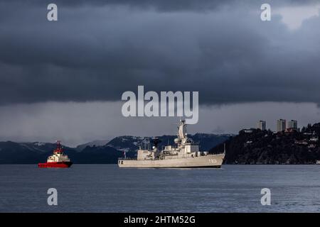 Niederländische Karel-Doorman-Klasse Fregatte F3831 HNLMS Van Amstel in Byfjorden, außerhalb des Hafens von Bergen, Norwegen. Schlepper BB Worker in der Nähe, um zu helfen. Stockfoto