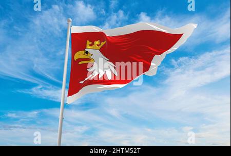 Flagge der Woiwodschaft Warmia-Masuren, wojewodztwo warminsko-mazurskie , Polen bei bewölktem Himmel Hintergrund bei Sonnenuntergang, Panoramablick. Polnisches Reisekonzept Stockfoto