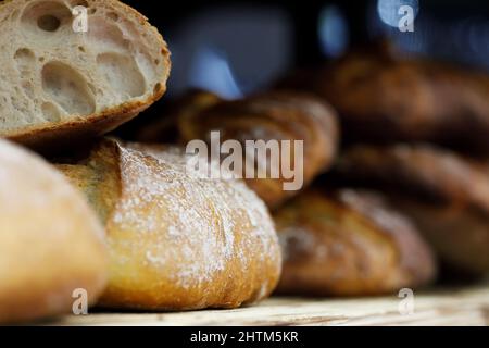 Frisch gebackene Brote auf einem Holzregal. Selektiver Fokus. Stockfoto