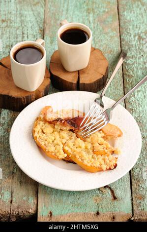 Quitten-Krümel-Kuchen und Kaffee auf handgefertigten Holzständern senkrecht Stockfoto