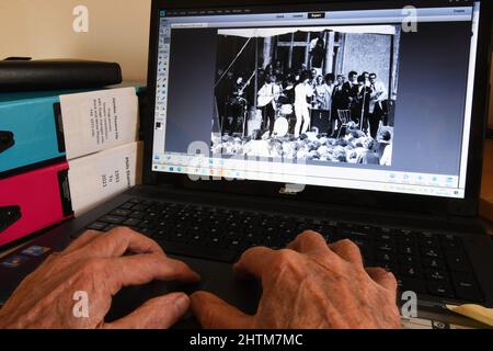 Alte Hände an einer Computertastatur, die Bilder finden, um angenehme Erinnerungen auszulösen, wenn man älter wird. Musik spielte in den 1960er Jahren eine wichtige Rolle im Leben Stockfoto