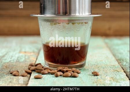 Kaffee in kleinen Metall Französisch Tropffilter auf Holztisch horizontal gebrüht Stockfoto