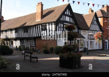 Fachwerkhäuser, schwarz-weiße Häuser, mit hängenden Körben und Blumenblüten, Sommerzeit, Shakespeare-Land. Malz Mill Lane, Alcester, Warwickshire, Großbritannien Stockfoto