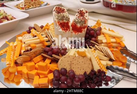 Elegante Aufzuchtplatte mit feinen Käsesorten, Früchten, Crackern und Keksen Stockfoto