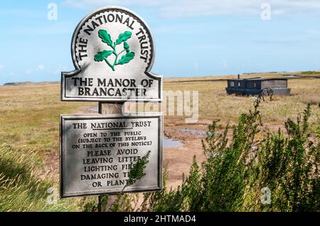 Schild des National Trust für das Manor of Brancaster in Brancaster Staithe an der Nord-Norfolk-Küste. Stockfoto