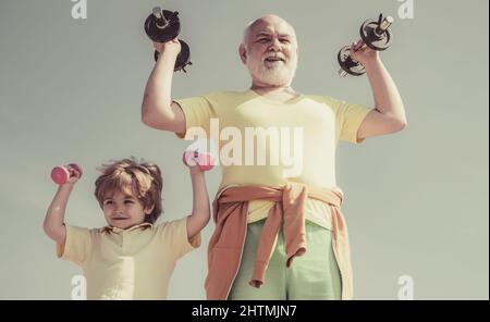 Aktives, gesundes Leben für die Familie. Motivations- und Sportbeispielkonzept. Großvater und Enkel mit Kurzhanteln in den Händen. Stockfoto