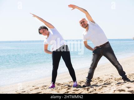 Ein Paar macht Yoga am Strand. Stockfoto