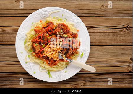 Leckere Spaghetti mit Fleischbällchen in Tomatensoße auf Holztisch Overhead View Copyspace Stockfoto