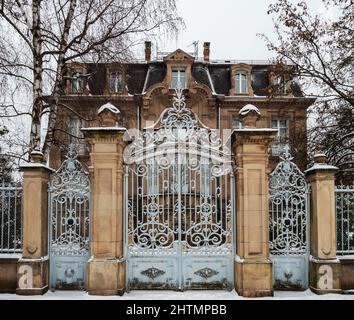 Ein altes Herrenhaus mit schönen Toren ist mit Schnee bedeckt. Straßburg Stockfoto