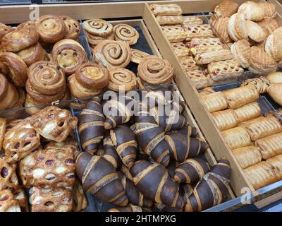 Frisch gebackenes, gefrorenes Blätterteig mit Marmelade und Frischkäse in der Bäckerei. Schokoladencroissants, Pudding und Zimtschnecken im Supermarkt. Frisches Dessert oder Nachmittagssnack Stockfoto