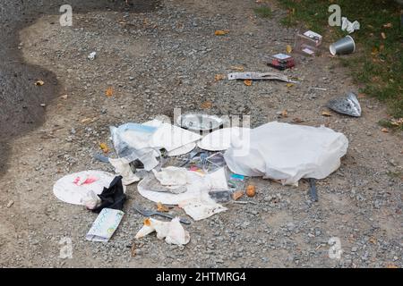 Recycelbarer Müll auf Schotterweg im öffentlichen Park weggeworfen. Stockfoto